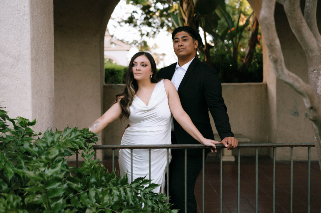 Engaged couple Lindsay and Ryan leaning on a railing at Balboa Park during their San Diego engagement session