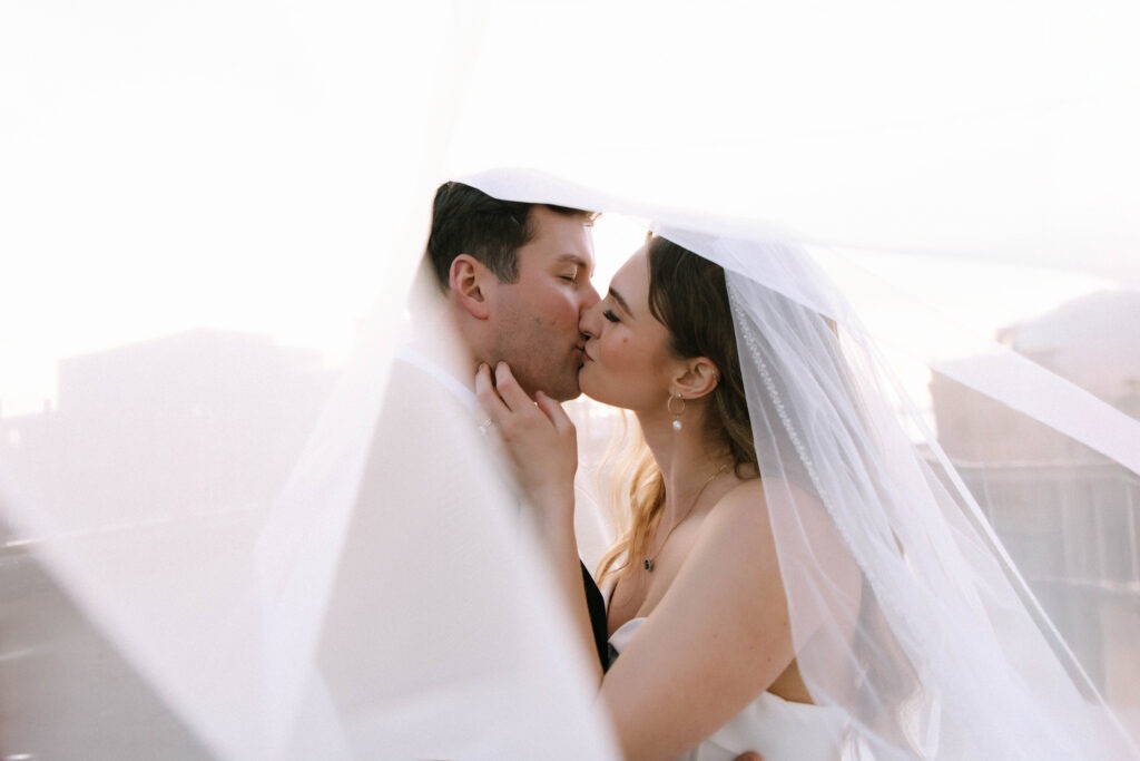 Bride and groom kissing beneath the veil during a romantic Europa Events wedding in Seattle, Washington